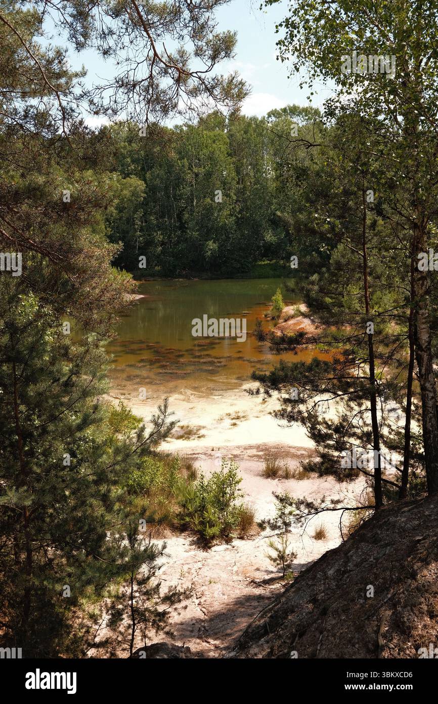 Lago rosso arrugginito con spiaggia sabbiosa Foto Stock
