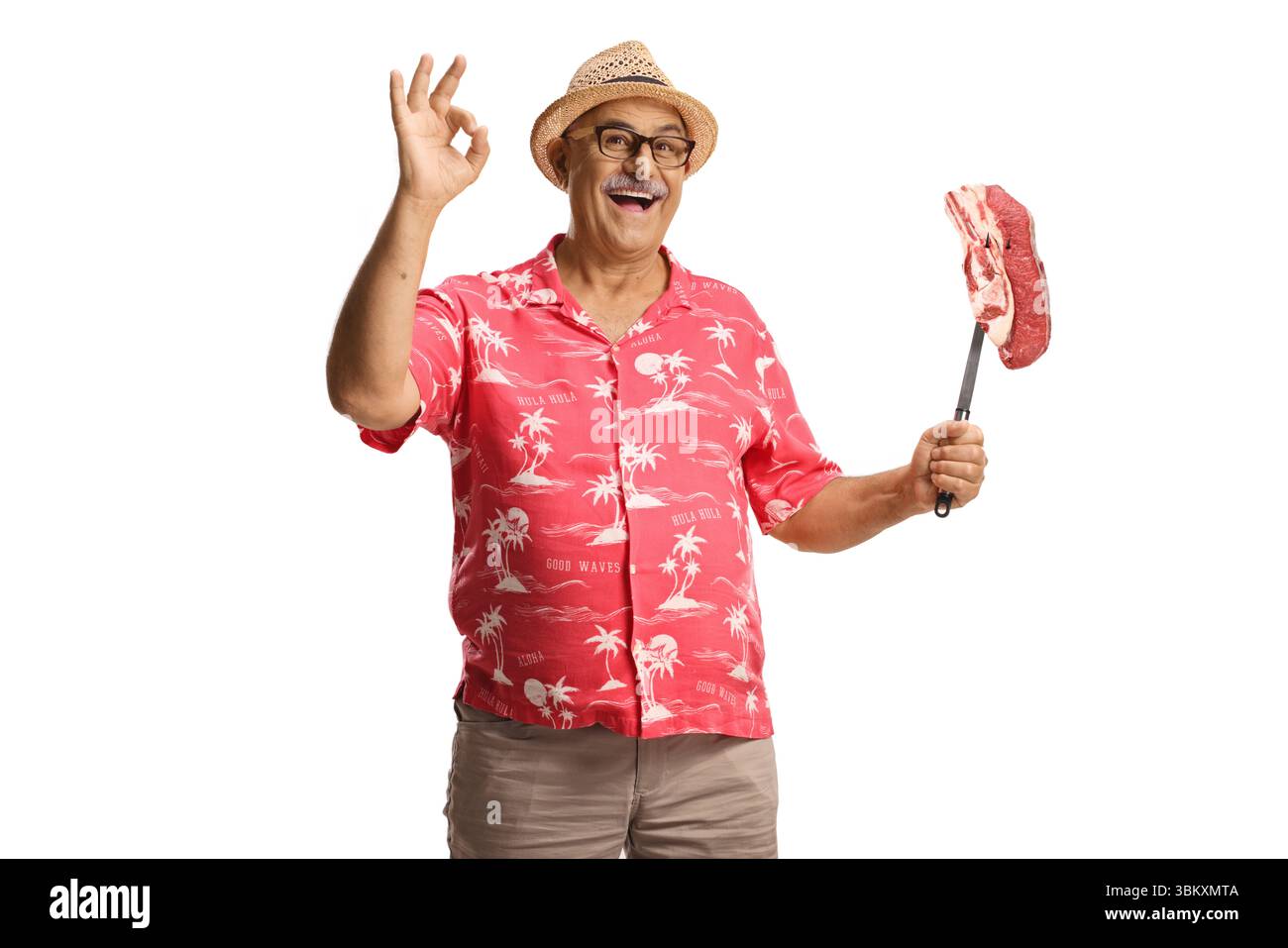 Uomo maturo felice che tiene in mano bistecca cruda con una forchetta isolata su sfondo bianco Foto Stock