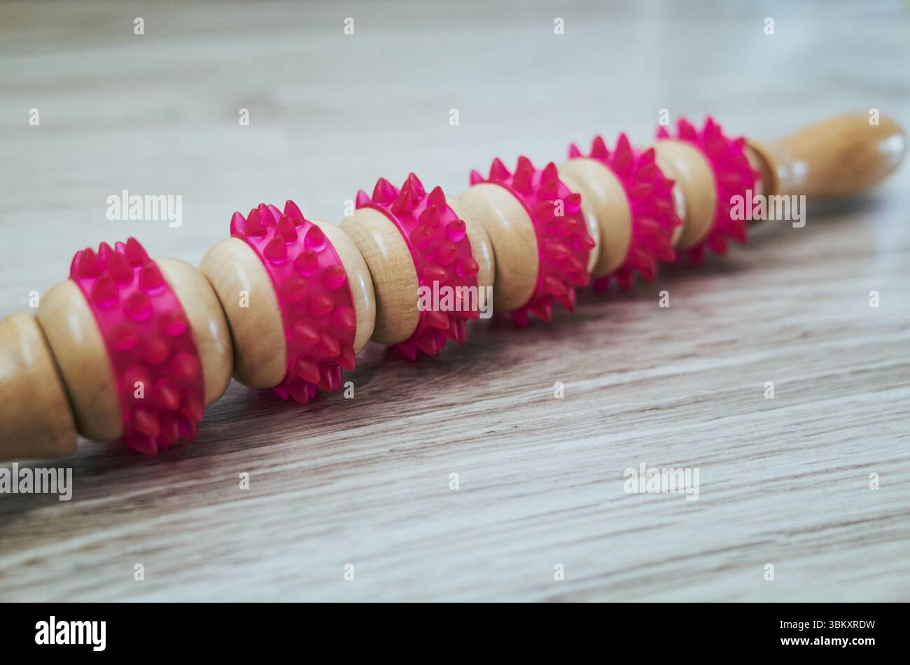 Rullo rosa e di legno con punte rosa. I picchi sono piccoli e distanziati uniformemente, conferendo al rullo un aspetto unico e ruvido. Il woo Foto Stock