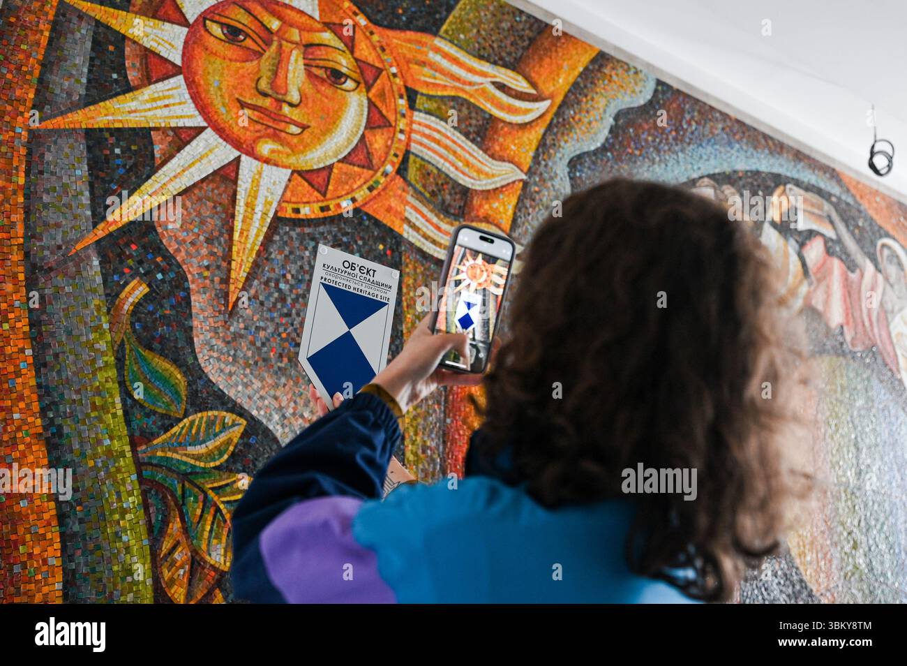 Non esclusiva: Il capo dell'Ufficio per la protezione dei beni culturali del Consiglio comunale di Leopoli Tetiana Balukova scatta una foto del mosaico dello spazio dell'informazione Foto Stock