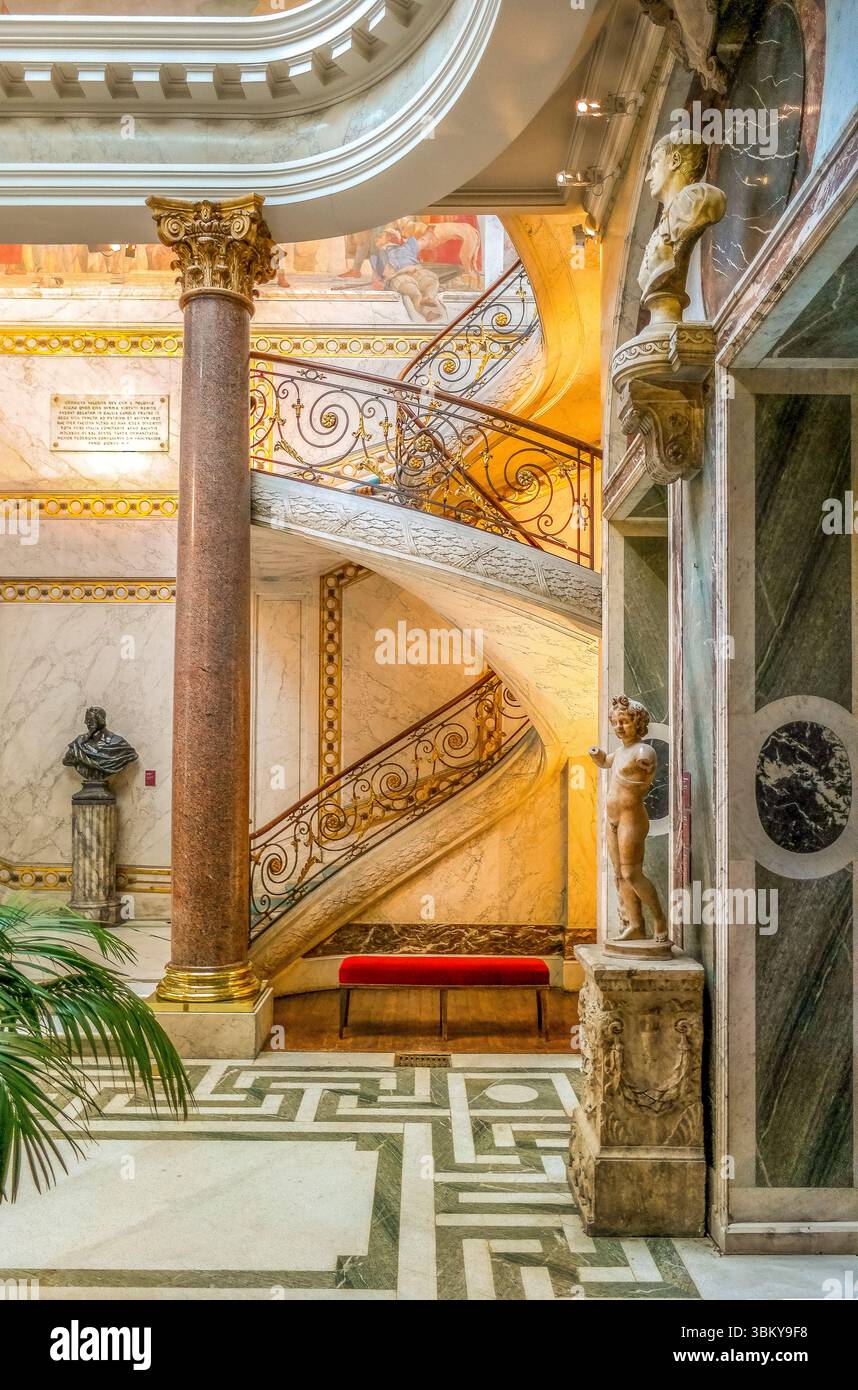 Parigi. Elegante scala a chiocciola interna al Musée Jacquemart-André con arredi dorati ornati, lampadario di cristallo e pavimenti in marmo Foto Stock