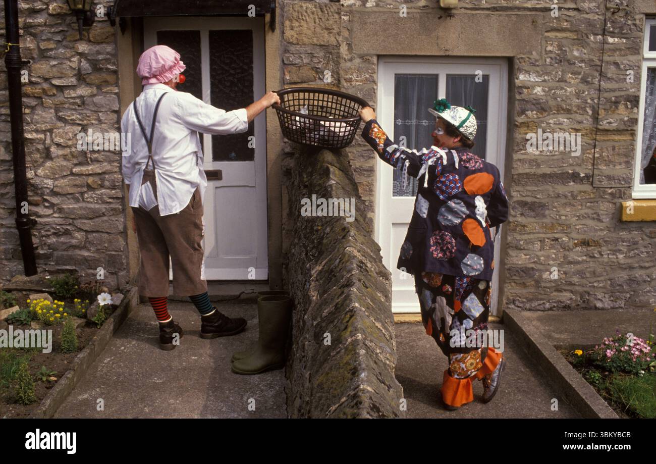 Festa di Bellerby villaggio tradizionale Spring Bank Holiday festival inglese. I clown e i "raccoglitori di torte di formaggio" camminano attraverso il villaggio con un cestino per raccogliere soldi, torte, dolci e premi di lotteria da tutti i proprietari del villaggio. Bellerby, North Yorkshire Inghilterra circa 1985 UK 1980s HOMER SYKES Foto Stock