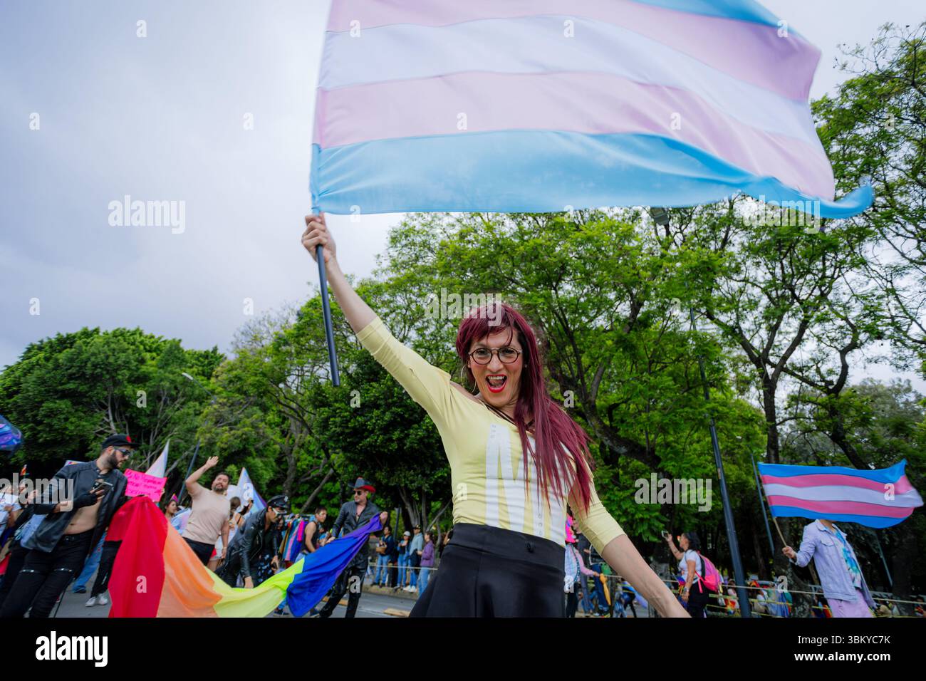 Una donna trans alza la bandiera transgender con orgoglio durante la LGBT+ Pride March della città. L'immagine rappresenta l'empowerment, la visibilità e l'id del sesso Foto Stock