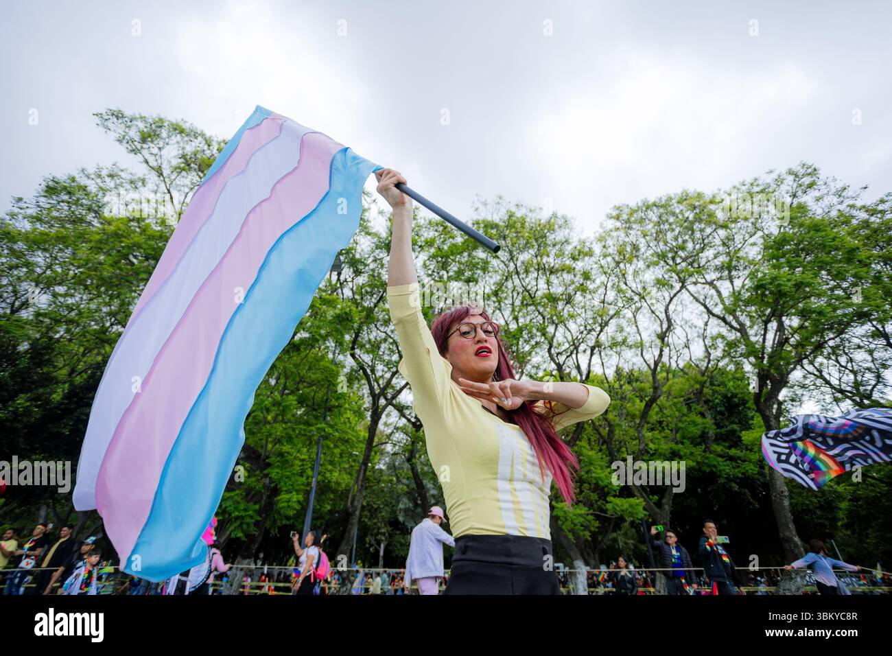Una donna trans alza la bandiera transgender con orgoglio durante la LGBT+ Pride March della città. L'immagine rappresenta l'empowerment, la visibilità e l'id del sesso Foto Stock
