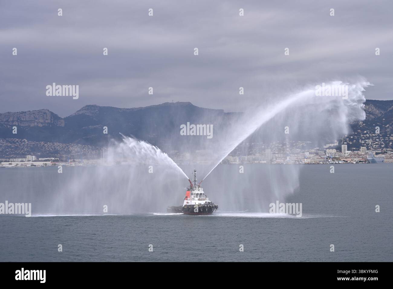 Rimorchiatore Chambon Mistral IMO 9161912 che fa un saluto per cannoni d'acqua con le sue manichette antincendio la Seyne-sur-Mer, Francia aprile Foto Stock