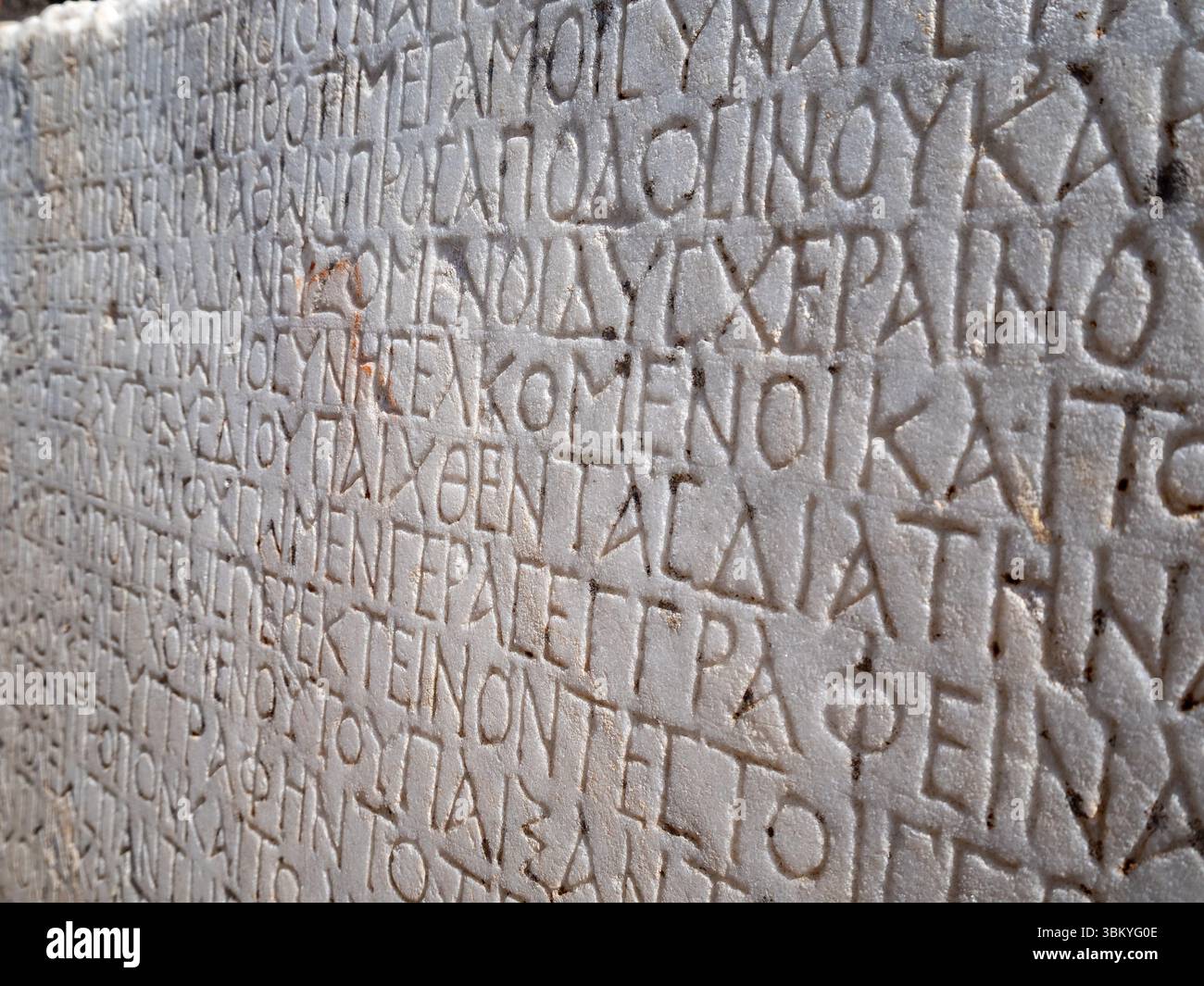 Uno scatto ravvicinato rivela un'antica tavoletta di pietra adornata con iscrizioni in greco, che mostra il significato storico e il patrimonio culturale dell'artefatto. Foto Stock