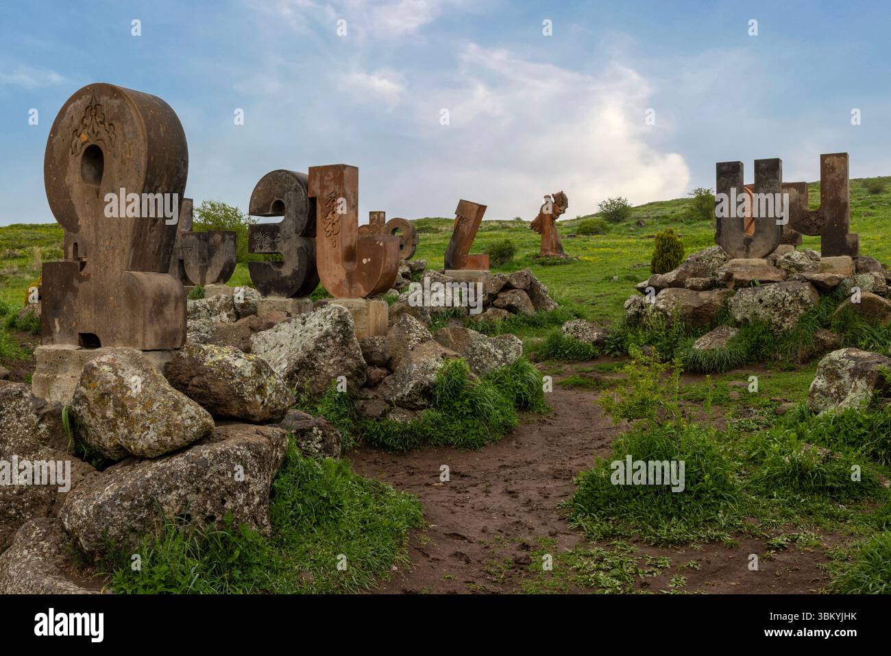 Le gigantesche lettere in pietra che celebrano la scrittura unica della nazione si stagliano sullo sfondo drammatico del Monte Aragats presso il Monumento all'alfabeto armeno. Foto Stock