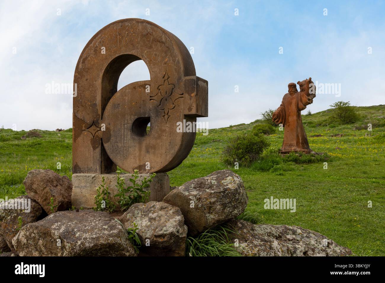Le gigantesche lettere in pietra che celebrano la scrittura unica della nazione si stagliano sullo sfondo drammatico del Monte Aragats presso il Monumento all'alfabeto armeno. Foto Stock