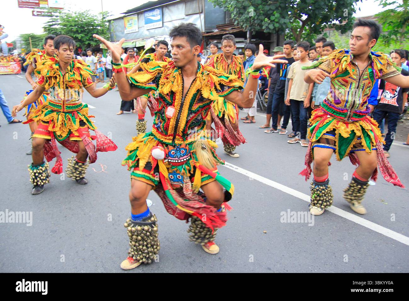 Gli uomini eseguono la tradizionale danza Gedruk Buto per strada durante un festival culturale. Foto Stock