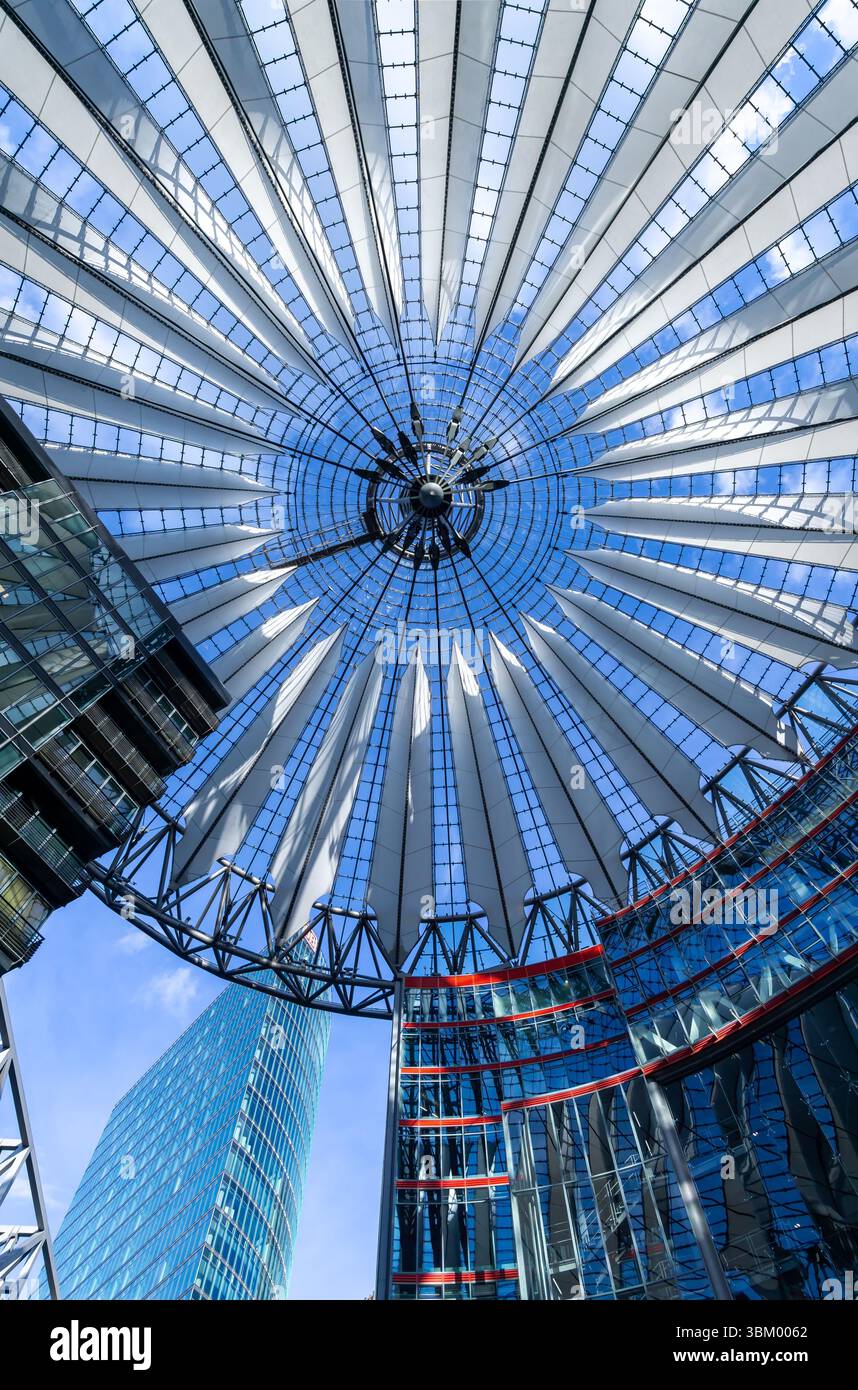 Tetto del Sony Center di Berlino con struttura geometrica e riflessi, vista parziale della BahnTower sullo sfondo. Foto Stock