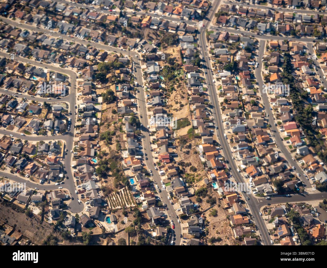 Una vista aerea mostra un quartiere periferico densamente popolato con case che fiancheggiano le strade, mostrando la pianificazione urbana e l'architettura residenziale. Foto Stock