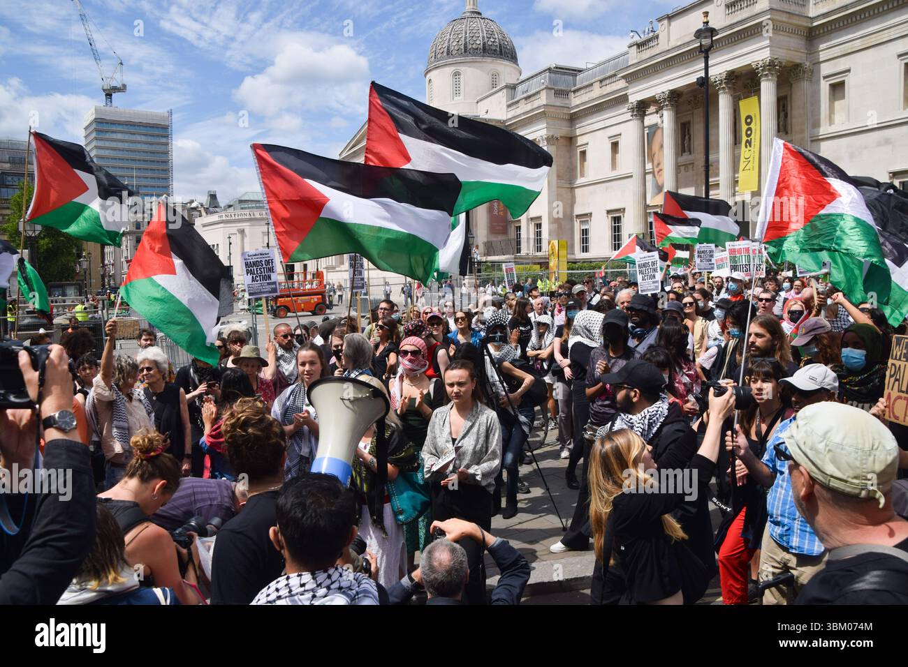 Londra, Regno Unito. 23 giugno 2025. I manifestanti tengono bandiere palestinesi durante la manifestazione. I sostenitori hanno organizzato una protesta a Trafalgar Square contro i piani del governo per vietare il gruppo di attivisti pro-Palestina Palestine Action. Credito: SOPA Images Limited/Alamy Live News Foto Stock