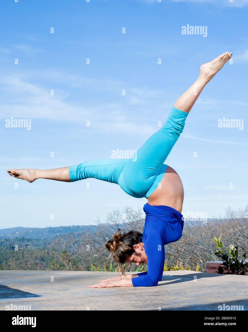 42 anni di gravidanza madre che fa una posa di yoga sirsasana Foto Stock