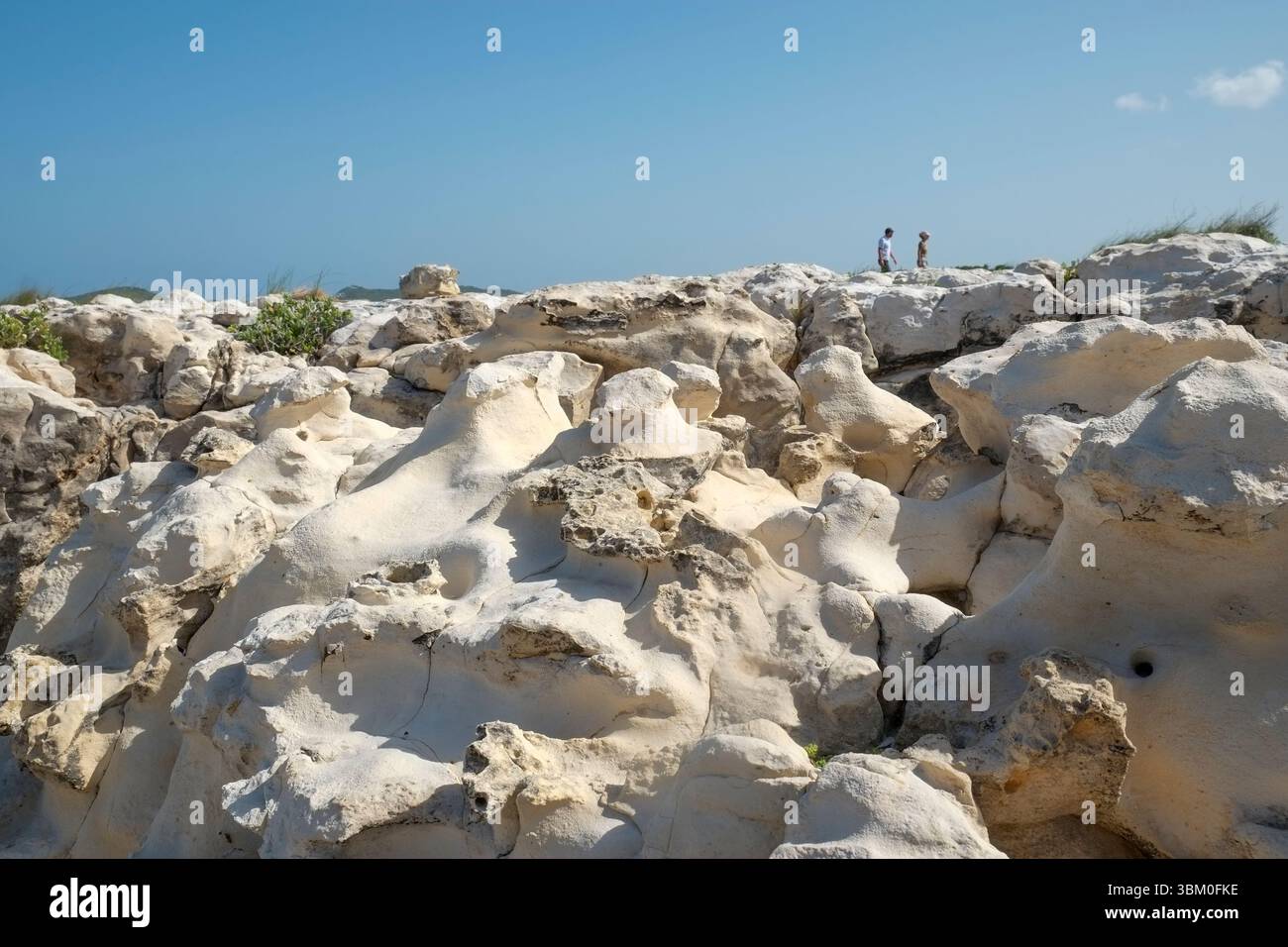 Antigua, Indie occidentali. Due persone tra le rocce. Foto Stock