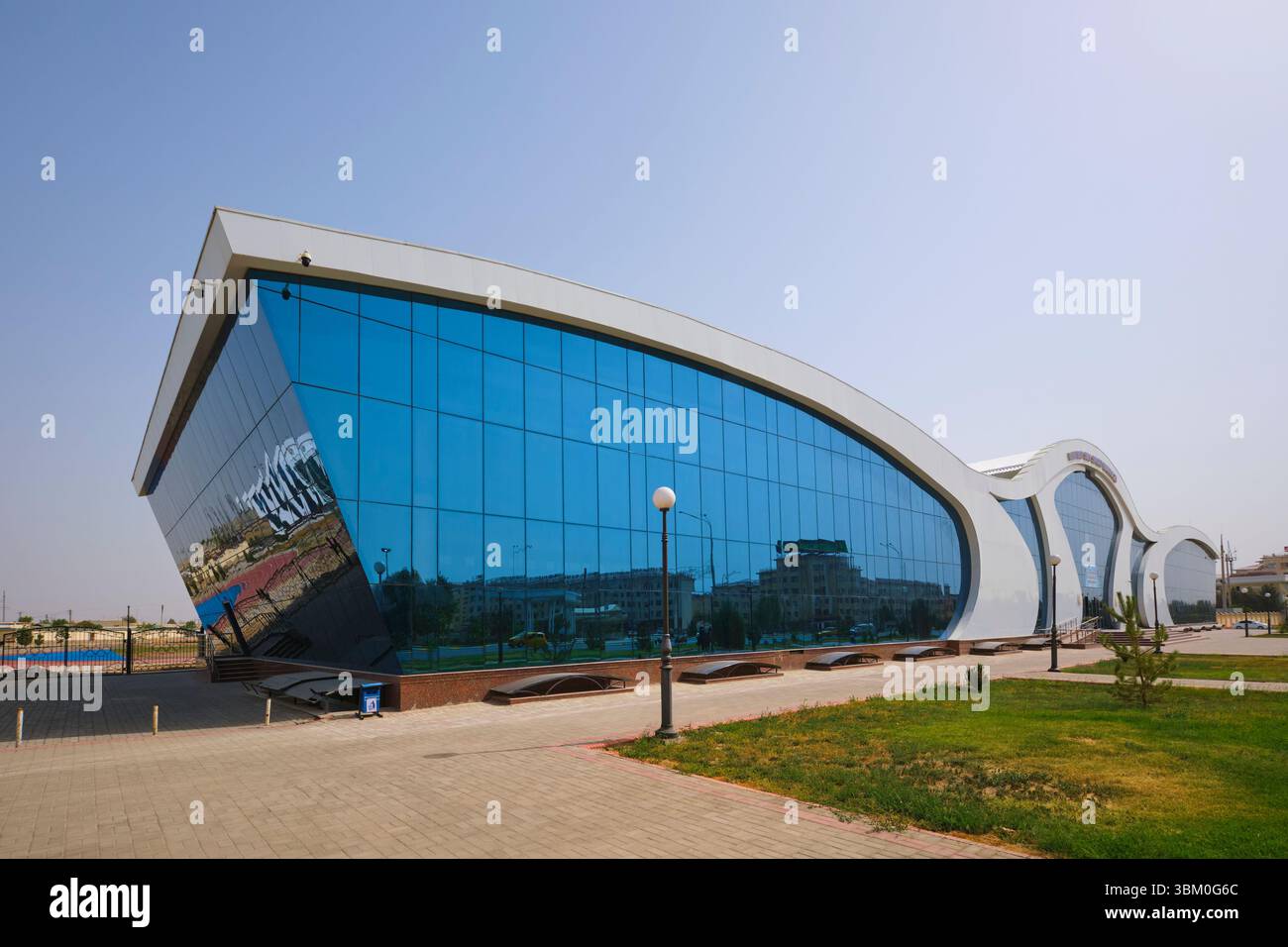 Vista del design moderno, bianco, in vetro, ondulato e curvato. Al moderno e curvato centro sportivo Megasportkomplex di Qarshi, Uzbekistan. Foto Stock