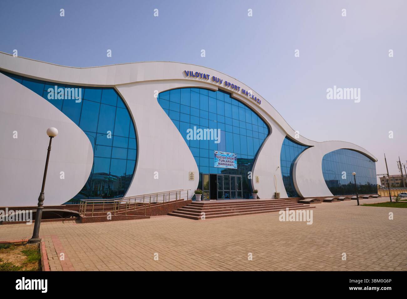 Vista del design moderno, bianco, in vetro, ondulato e curvato. Al moderno e curvato centro sportivo Megasportkomplex di Qarshi, Uzbekistan. Foto Stock