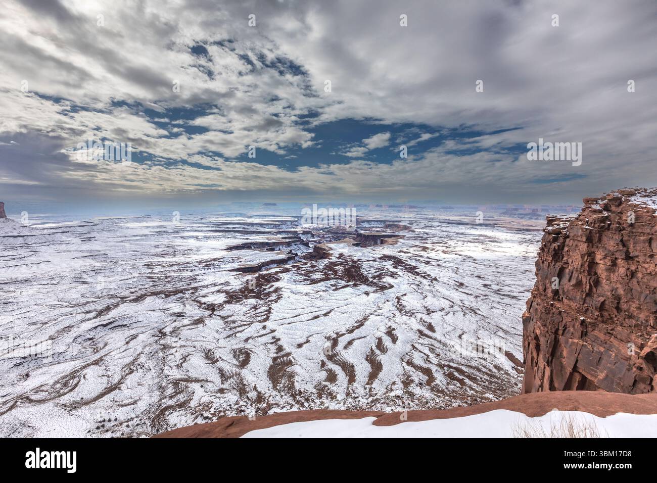 Una leggera nevicata e un terreno a contrasto di colore arancione caratterizzano l'aspro paesaggio del Parco Nazionale delle Canyonlands. Foto Stock