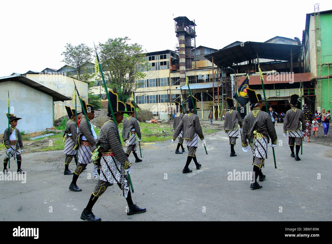 La sfilata di soldati che sorvegliano la tradizione del matrimonio con la canna da zucchero entra nel complesso della fabbrica. Foto Stock