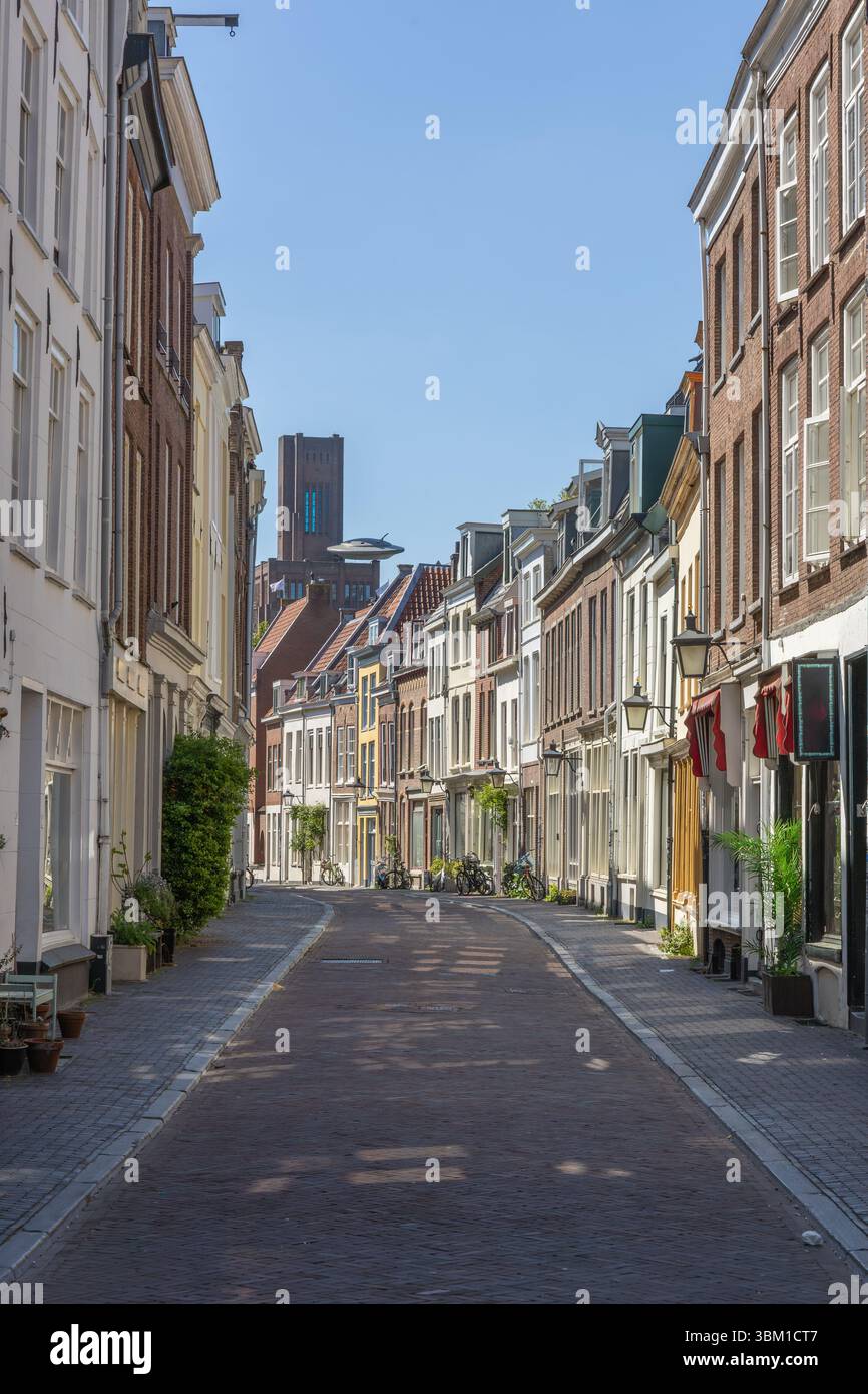 Incantevole vista sulla strada di Utrecht con edifici colorati che costeggiano una strada tranquilla, il "inktpot" visibile in lontananza con UFO sotto un cielo limpido. Foto Stock