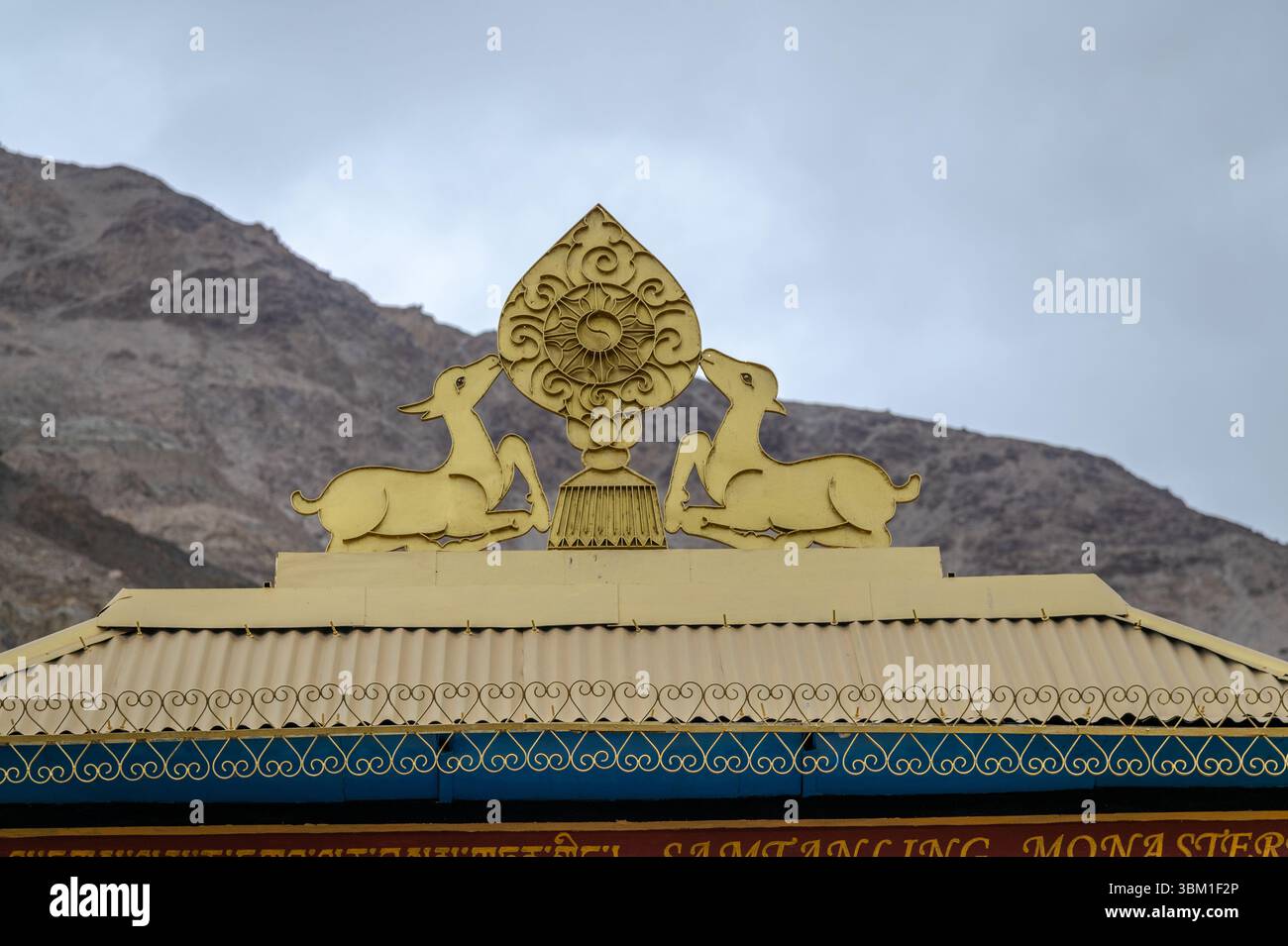 Primo piano di cervi dorati e ruota del Dharma sul tetto del monastero buddista a Ladakh, India Foto Stock