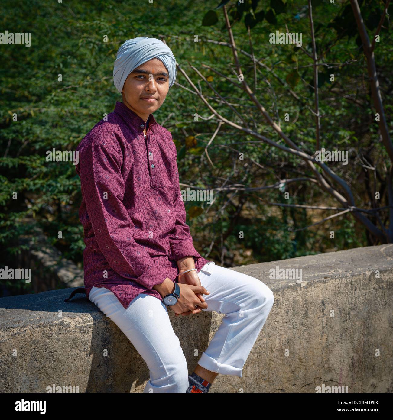 India, Jaipur, 22 giugno 2025. Ritratto di un giovane uomo locale in abbigliamento tradizionale, seduto all'aperto a Jaipur. Foto Stock