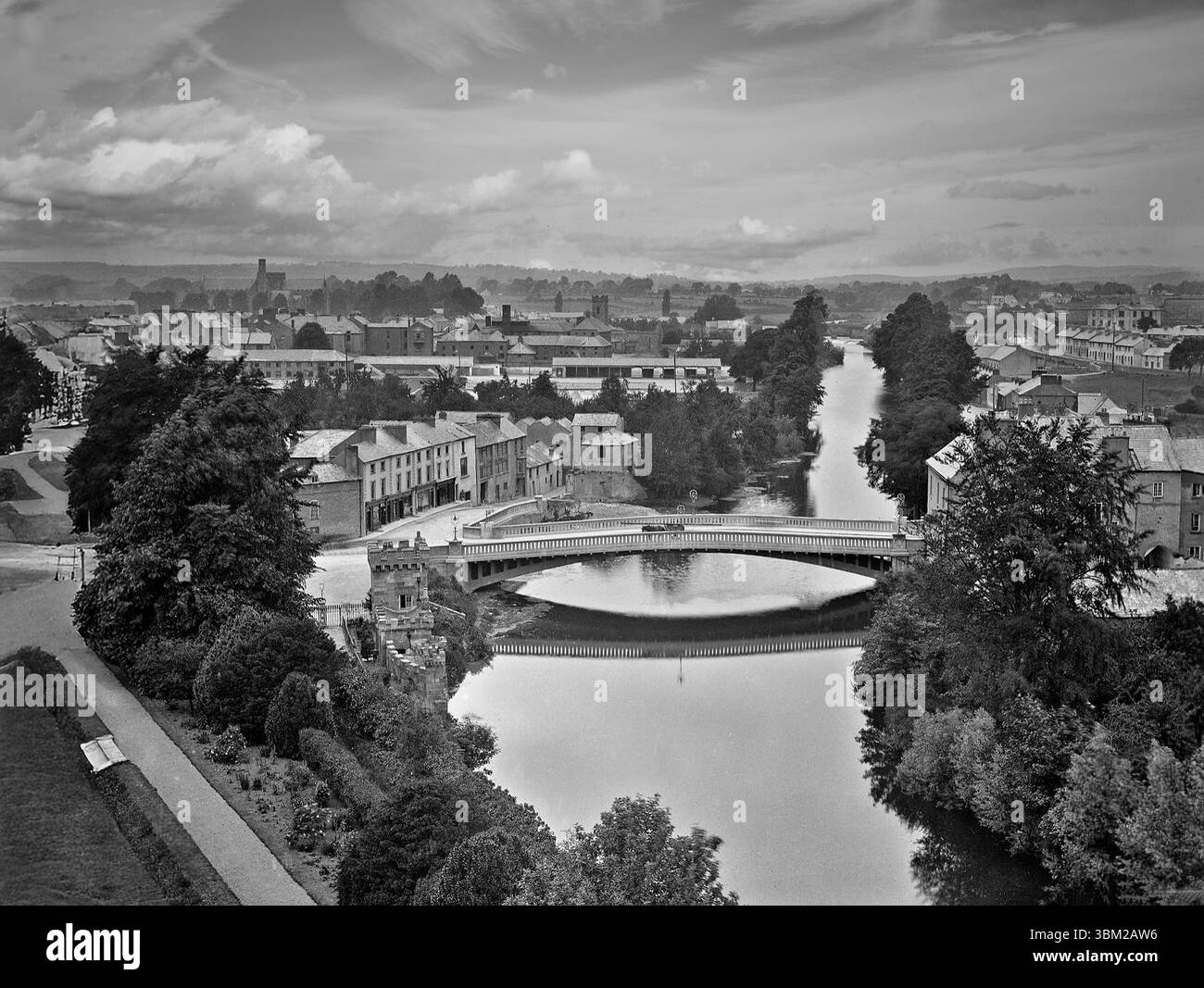 Una fotografia aerea della fine del XIX secolo del John's Bridge collega John Street a Rose Inn Street mentre attraversa il fiume Nore a Kilkenny City, in Irlanda. Fu costruito per la prima volta dopo il 1200, e fu ricostruito molte volte dal XII secolo a causa delle inondazioni. L'attuale John's Bridge fu completato nel 1910 e si estendeva per 140 piedi (43 m) era ritenuto, al momento del completamento, il più lungo ponte rinforzato a campata singola in Irlanda o in Gran Bretagna. Foto Stock