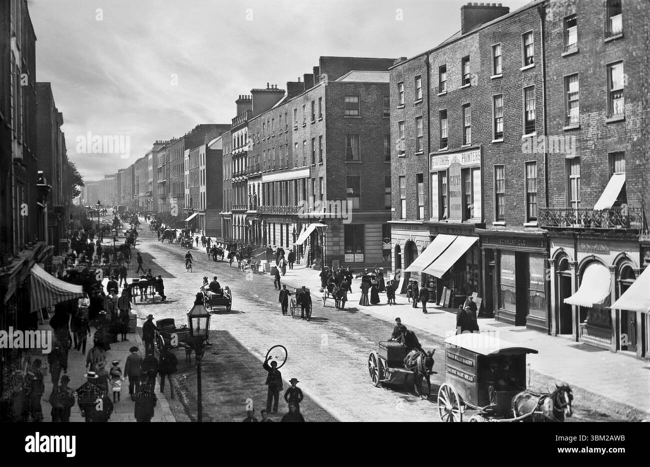 Una fotografia del tardo XIX secolo di o'Connell Street, precedentemente conosciuta come George's Street, la strada principale della città di Limerick. La strada corre in parallelo al fiume Shannon e forma parte di una strada principale, ed è lunga circa un miglio, partendo dall'incrocio tra Arthurs Quay e Denmark Street e terminando alla Crescent. Foto Stock
