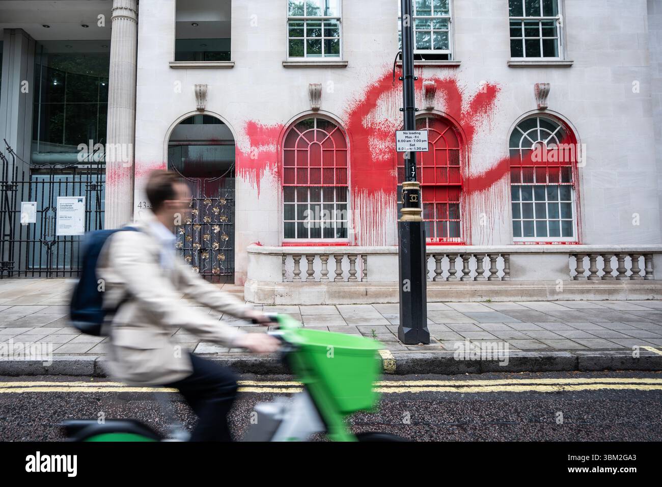 Londra, Regno Unito. 24 giugno 2025. Un ciclista passa davanti alla sede centrale di INVESCO, che è stata ricoperta di vernice rossa da Palestine Action. Palestine Action ha attaccato il quartier generale di INVESCO nella sua campagna in corso mirando alle compagnie coinvolte nell'armo di Israele. Il gruppo della campagna elettorale dovrebbe essere proscritto dal governo britannico per le sue attività di incendio doloso e vandalismo. Credito: SOPA Images Limited/Alamy Live News Foto Stock