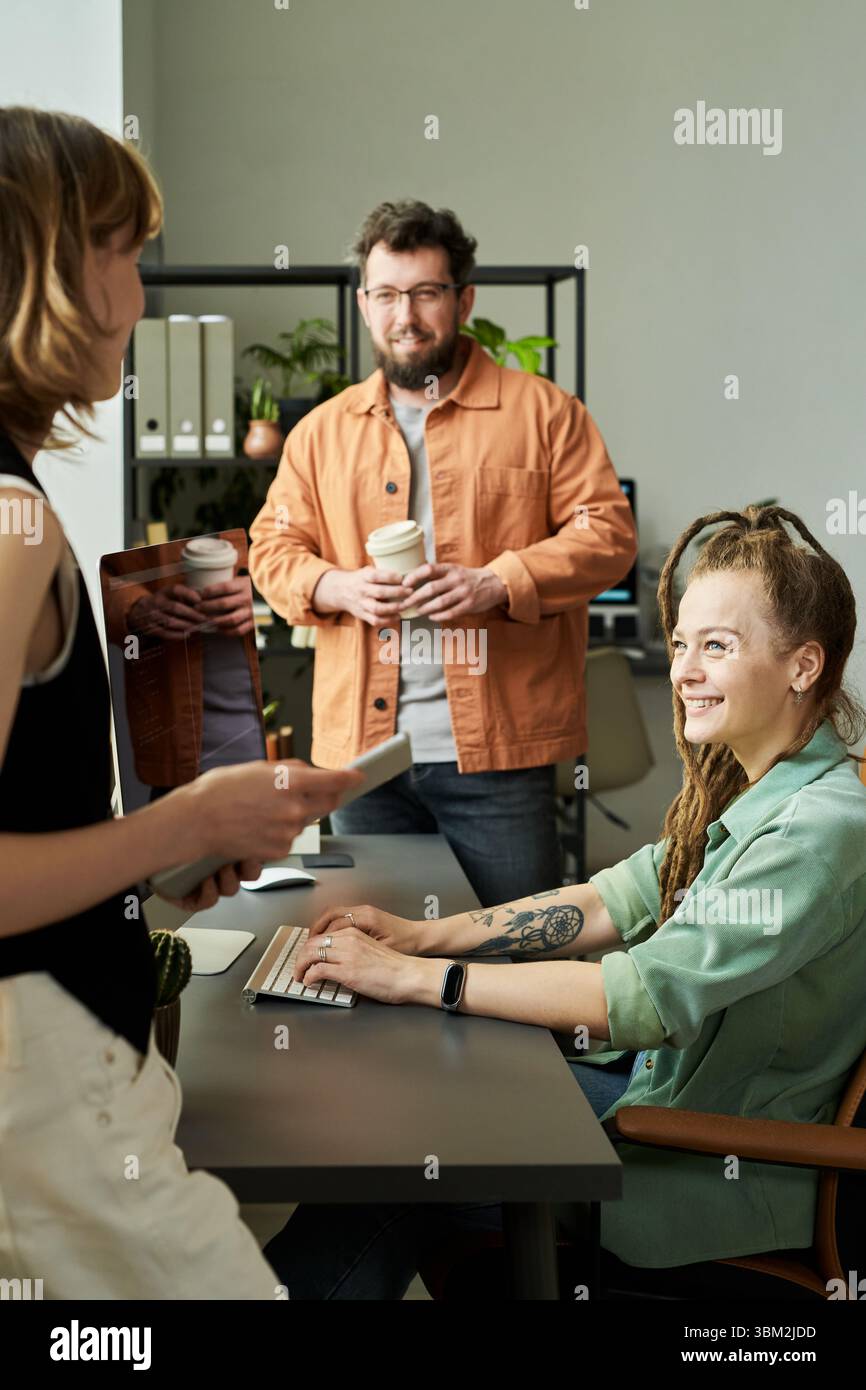 Team multietnico di giovani adulti che si occupano di brainstorming di soluzioni per reti neurali Foto Stock