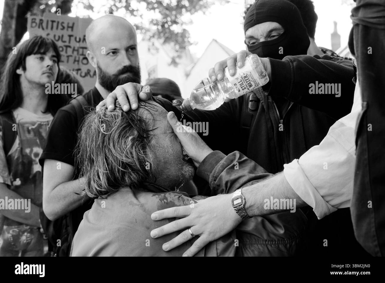 Un uomo sconosciuto dal lato antifascista della protesta UKIP riceve il primo soccorso dopo essere stato presumibilmente spruzzato al pepe dalla polizia Foto Stock