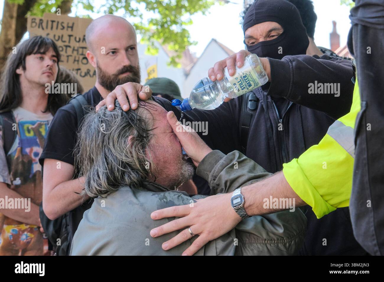 Un uomo sconosciuto dal lato antifascista della protesta UKIP riceve il primo soccorso dopo essere stato presumibilmente spruzzato al pepe dalla polizia Foto Stock