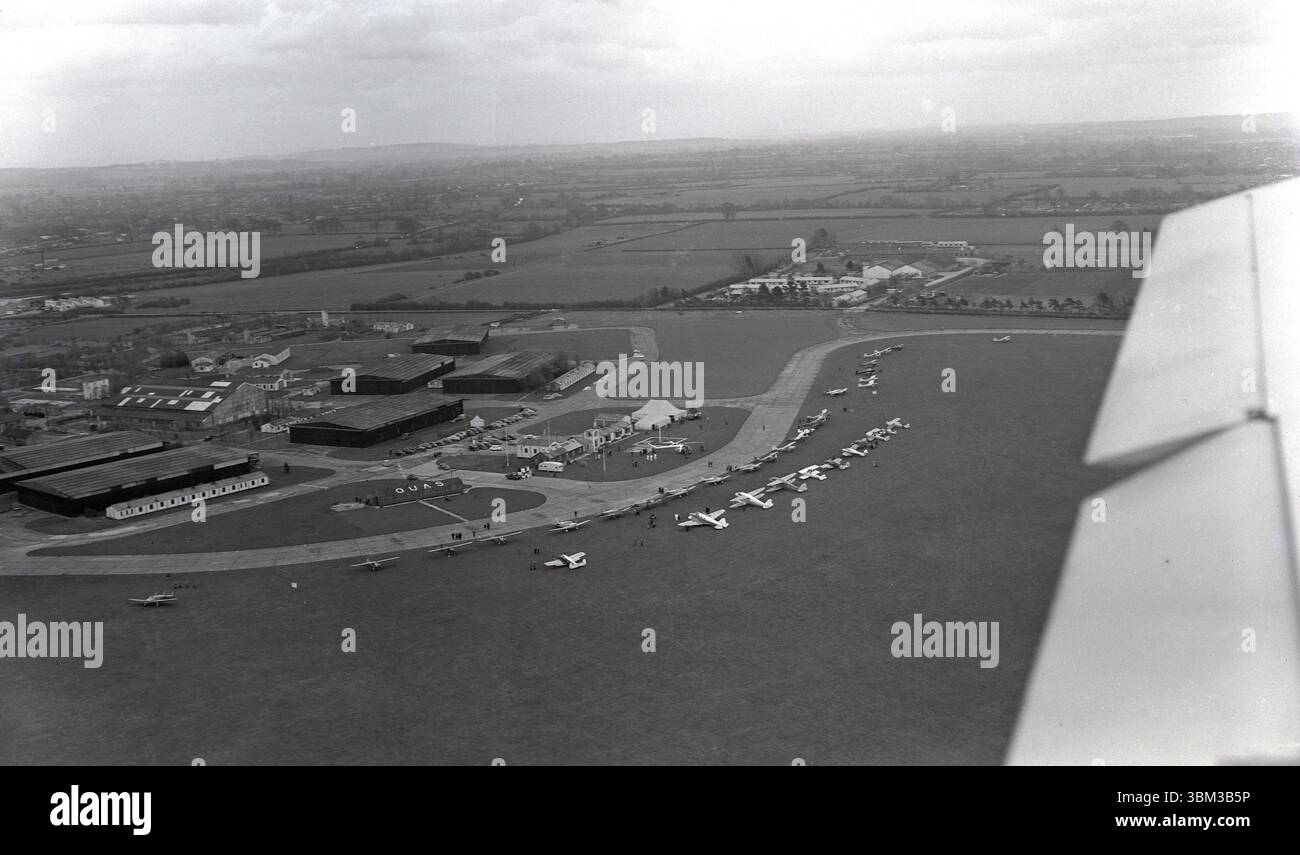 1950s, vista aerea storica del Bicester Airfield, Oxfordshire, Inghilterra, Regno Unito. Un appendiabiti nella foto di ha le lettere OUAS sul suo tetto, abbreviazione dell'Oxford University Air Squadron, che aveva sede lì in quest'epoca e vi rimase fino al 1975. Uno dei numerosi squadroni dell'unversity, l'OUAS è stato formato nel 1925 ed è il secondo più antico nel Regno Unito dopo l'Università di Cambridge. Foto Stock