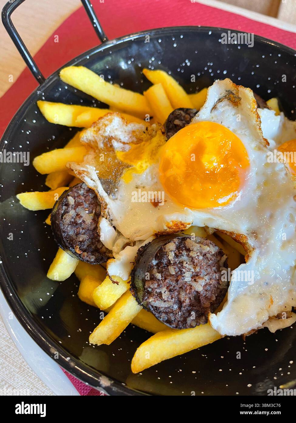 Uovo fritto con budino nero e patatine. Spagna. - Immagine stock catturata con smartphone
