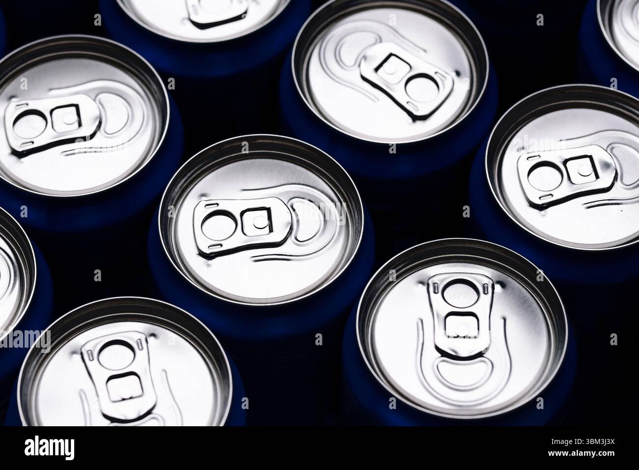 Vista dall'alto delle bibite in metallo. Coperchi in alluminio lucido. Confezionamento di bevande rinfrescanti. Schema delle lattine di bibite gassate. Produzione di bevande industriali. Foto Stock