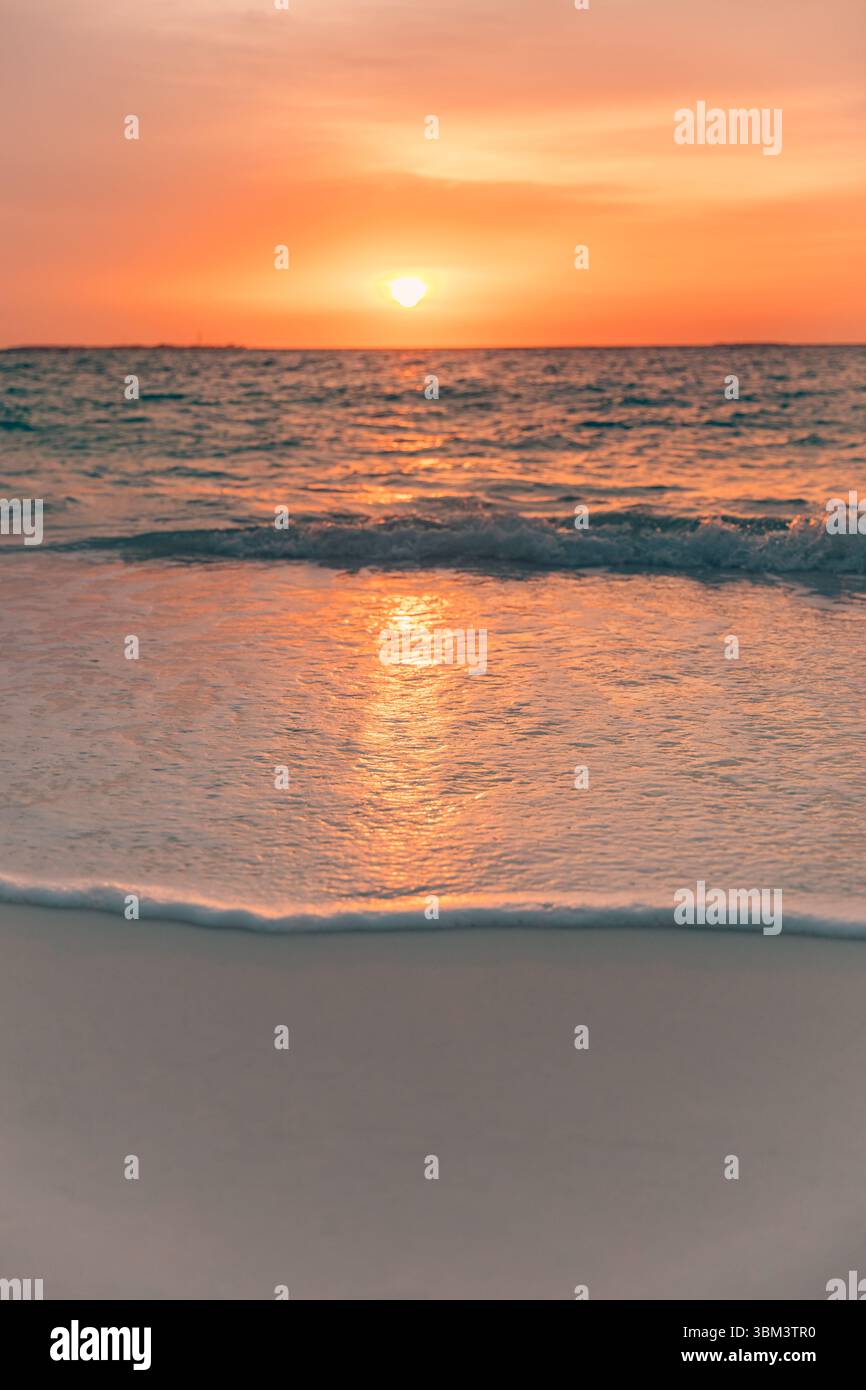 Splendido tramonto sul mare sulle calme onde della baia all'orizzonte sotto nuvole di cielo da sogno, luce del sole dorata, vista sull'oceano, vacanza estiva sullo sfondo della spiaggia Foto Stock