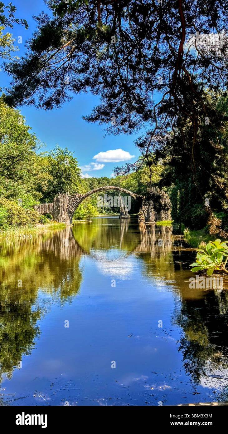 Ponte del Diavolo nel Rhododendron Park Kromlau, Germania, riflesso magico Foto Stock