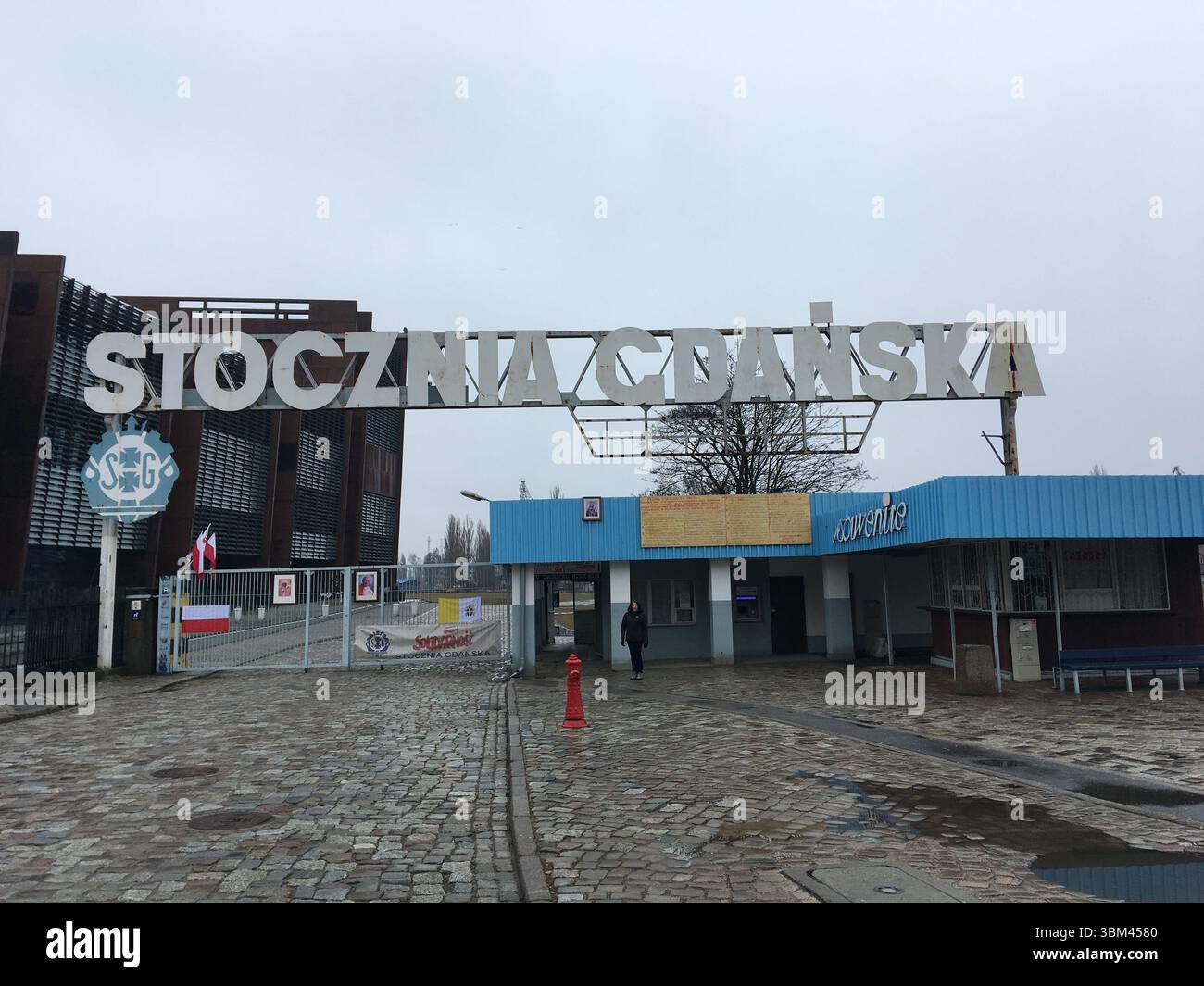 Storico cantiere navale di Gdańsk sulla Martwa Wisła, luogo di nascita di Solidarity, con gru, banchine e reliquie industriali che incorniciano storie di lavoro, protesta e. Foto Stock