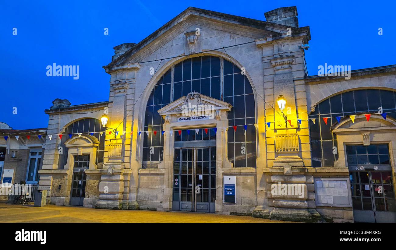 Il mercato municipale della città atlantica francese Soulac sur Mer la sera con lanterne e bandiere nei colori della bandiera nazionale francese Foto Stock