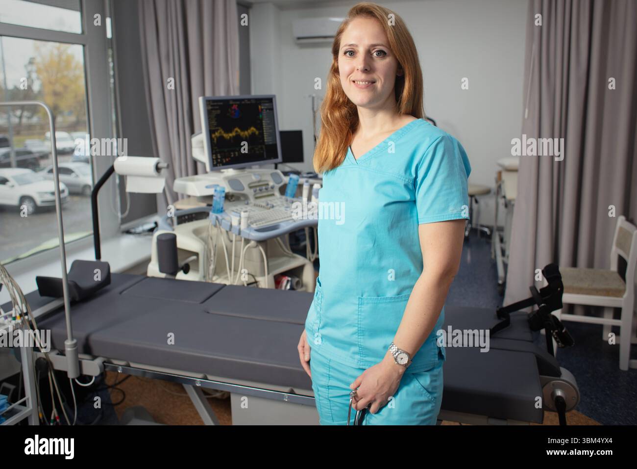 Сardiologist nel suo ufficio vicino a dispositivi medici. Un medico di riabilitazione in un centro medico vicino ai moderni dispositivi medici in attesa di un paziente. Foto Stock