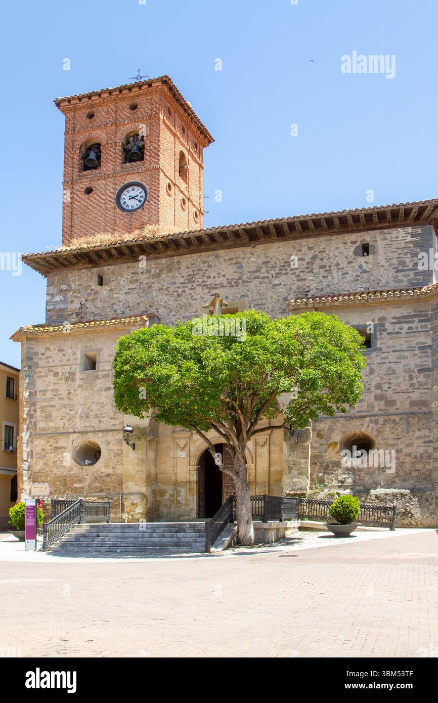 Persone che camminano accanto alla chiesa cattolica Iglesia de San Pedro nella città spagnola di Belorado Foto Stock