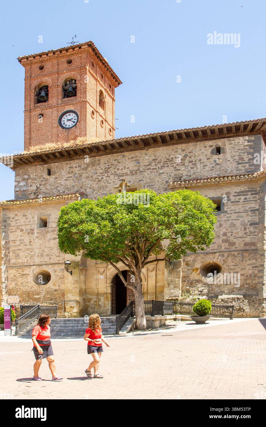 Persone che camminano accanto alla chiesa cattolica Iglesia de San Pedro nella città spagnola di Belorado Foto Stock