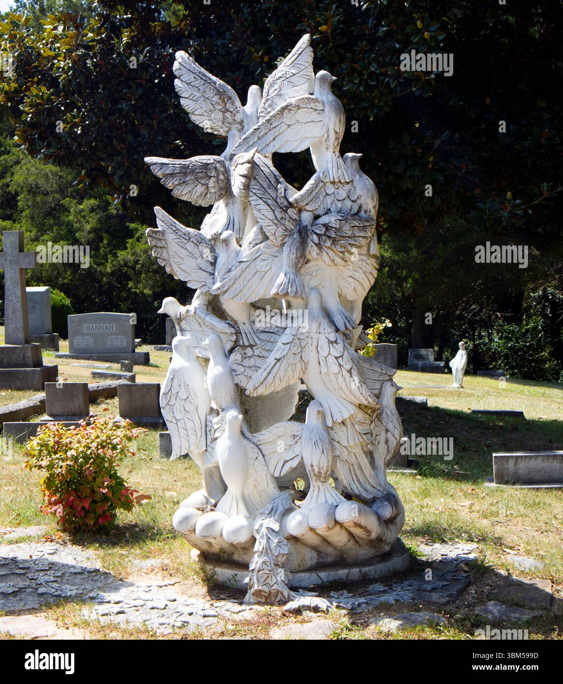 Tranquillo cimitero con statue di angeli e colombe immerse nella luce del sole all'Oakwood Cemetery di Raleigh, North Carolina. Foto Stock