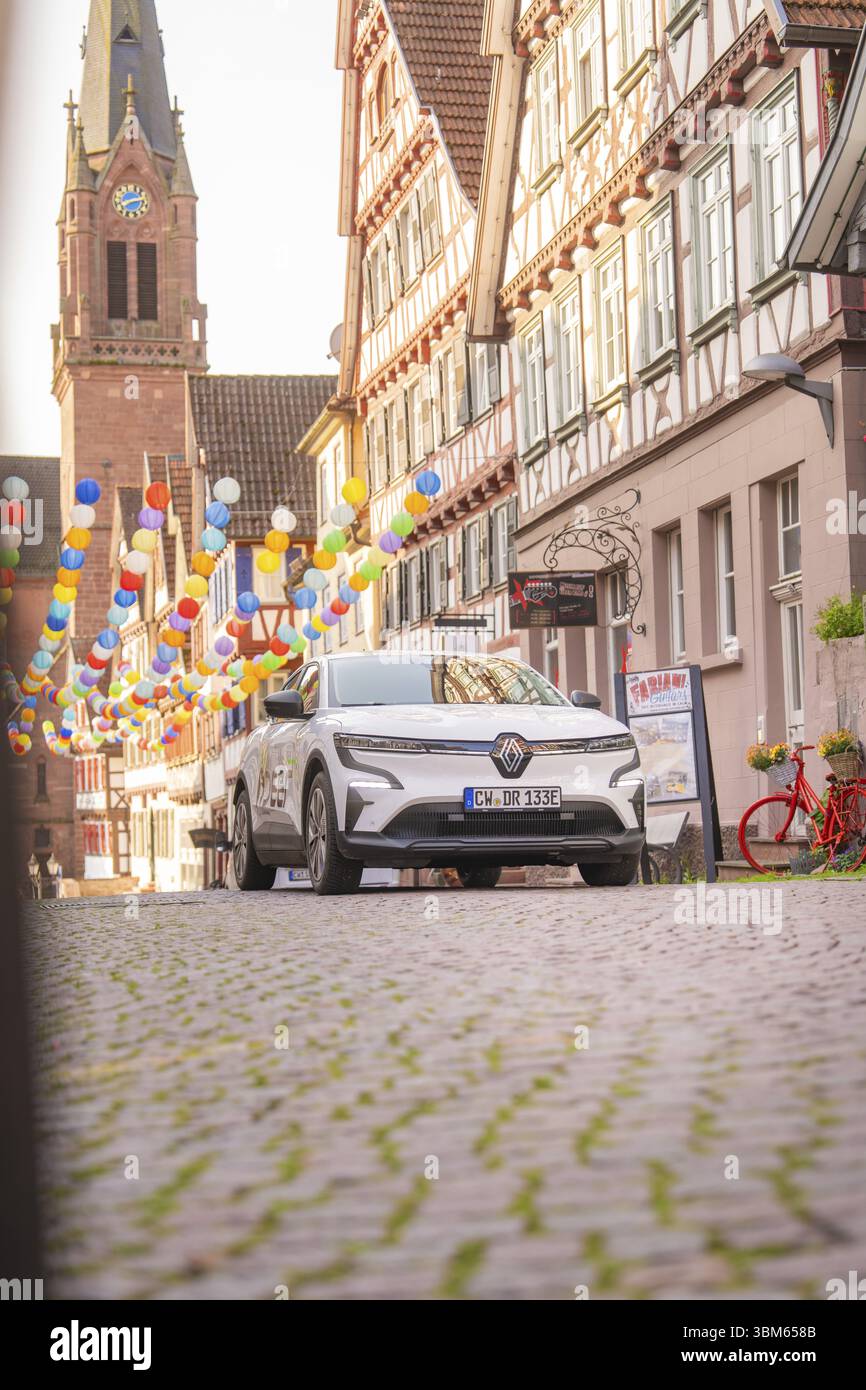 Un'auto su una strada acciottolata con case in legno e mongolfiere, Deer e, car sharing, auto elettrica, Calw, foresta Nera Foto Stock