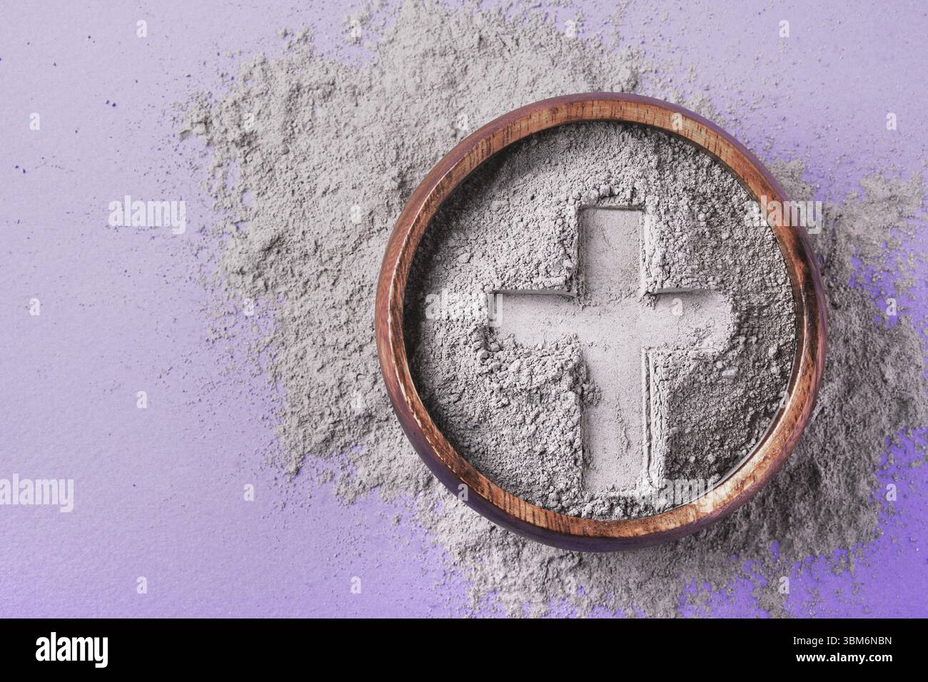 Kreuzaufdruck in grauer Asche auf lila Hintergrund. Aschermittwoch Foto Stock