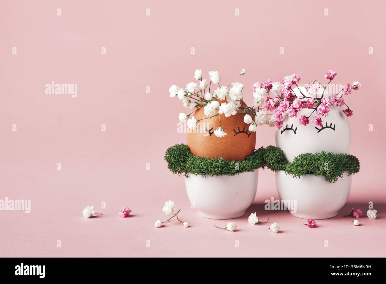 Uova di Pasqua bianche e nere con corona di fiori naturali. Il concetto di Pasqua zero rifiuti. Simbolo dell'uguaglianza razziale Foto Stock