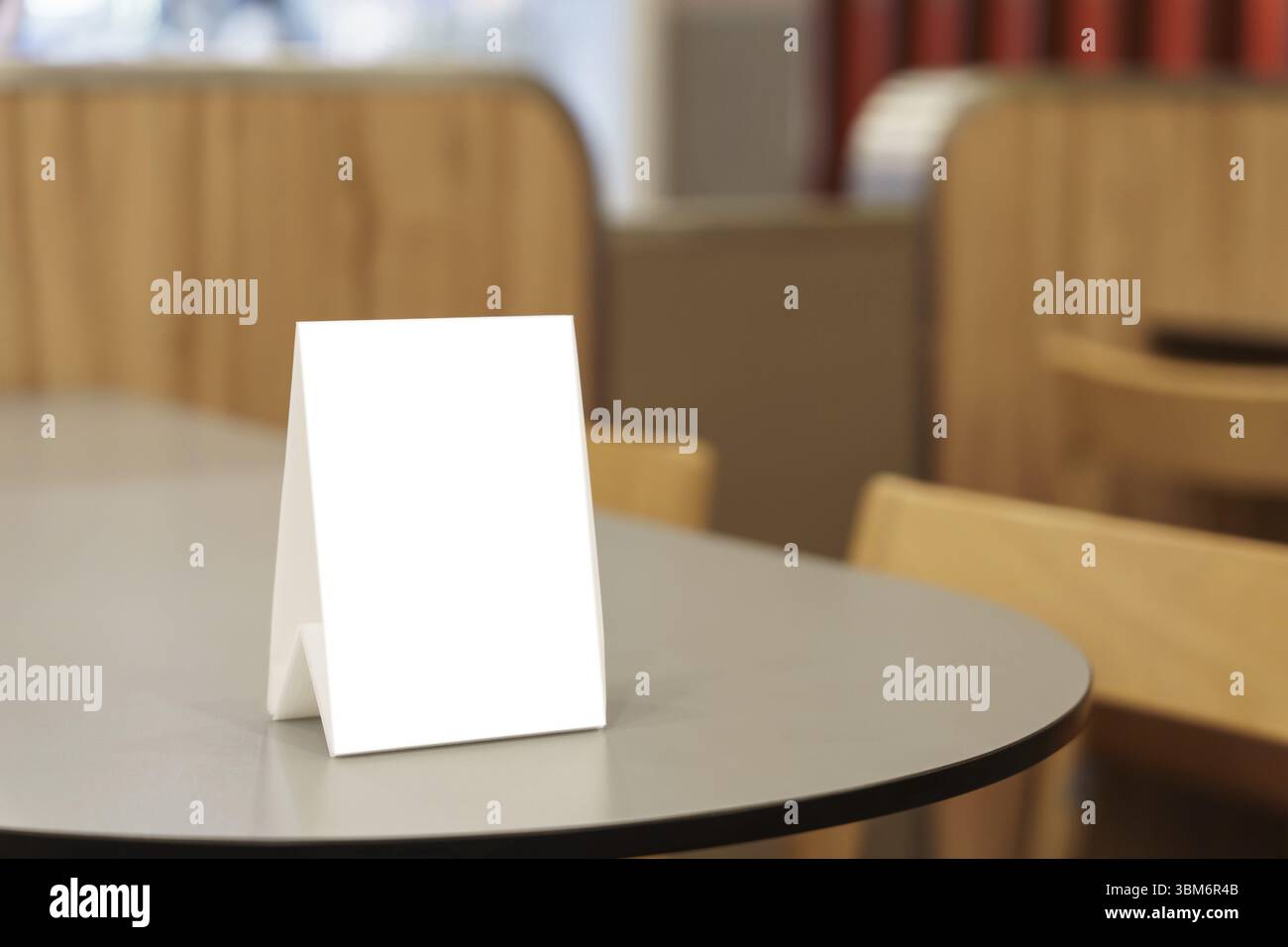 Modello del menu vuoto per la promozione di marketing testuale. Cornice del menu mock-up in piedi su un tavolo di legno nello spazio ristorante per il testo Foto Stock