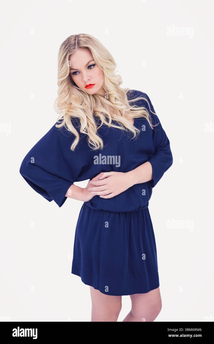 Giovane donna in piedi contro uno sfondo bianco Foto Stock