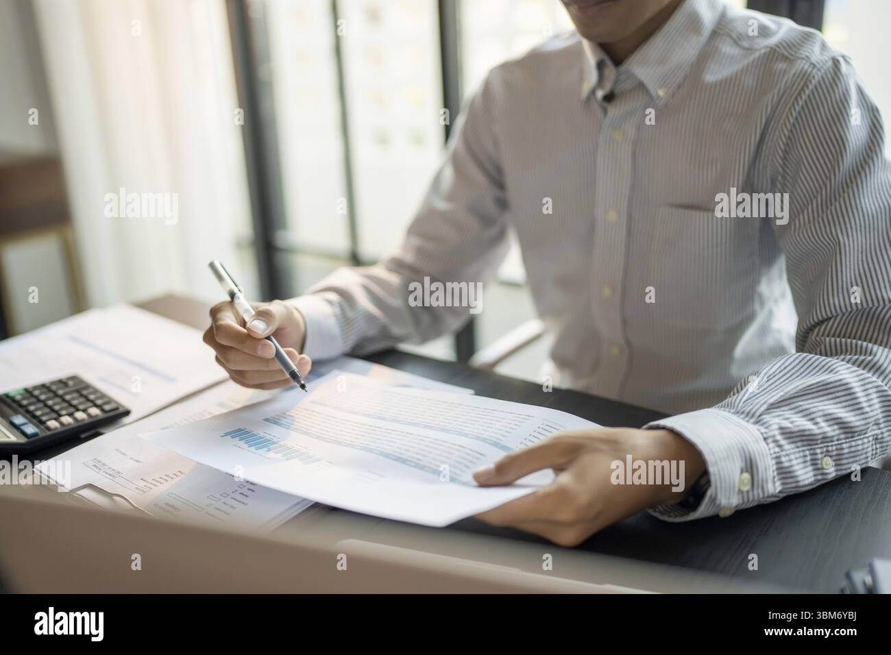 Primo piano di mani d'affari firma o scrittura di documenti cartacei e report analisi revisore appunti professionali maschili con Business Docu Foto Stock