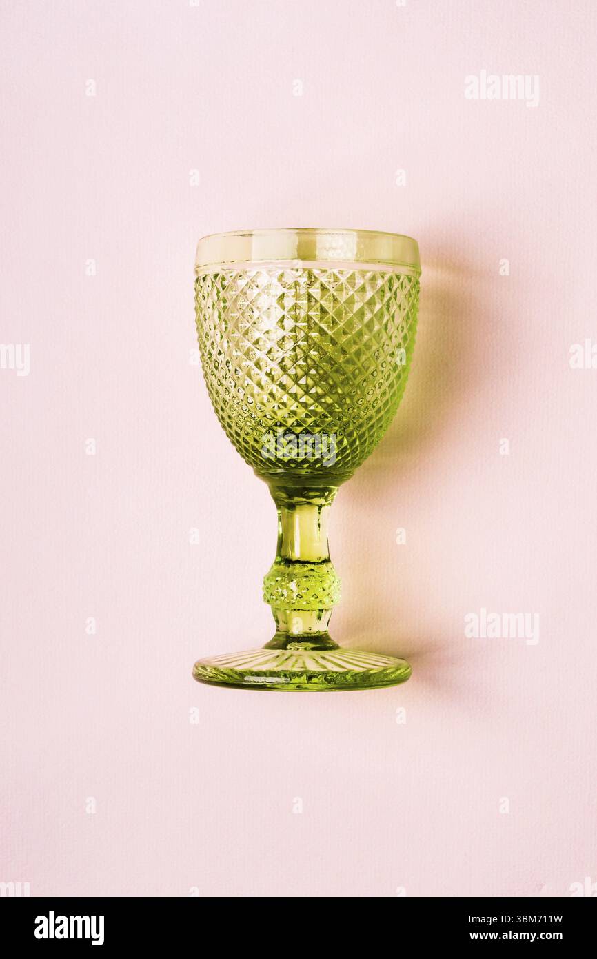 Lussuoso bicchiere di vino Vintage verde su sfondo rosa pastello Foto Stock