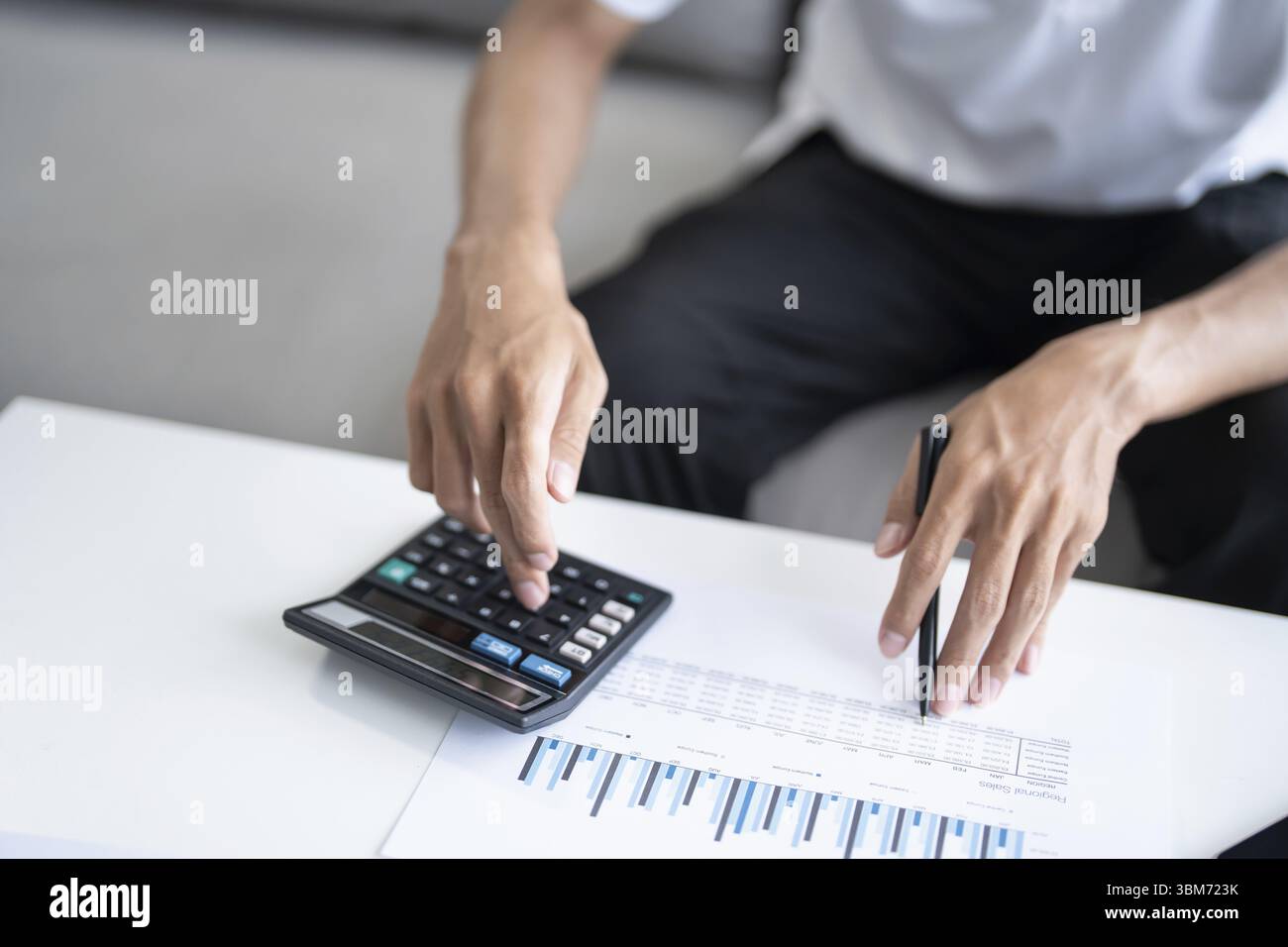 L'uomo calcola le finanze la casa paga le bollette le tasse sul telefono cellulare e calcolatrice finanziaria a casa Foto Stock